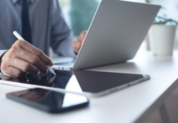 Homem elaborando tradução juramentada por assinatura digital no tablet.