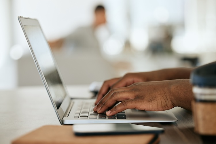 Mulher usando computador para pesquisar serviço de tradução.