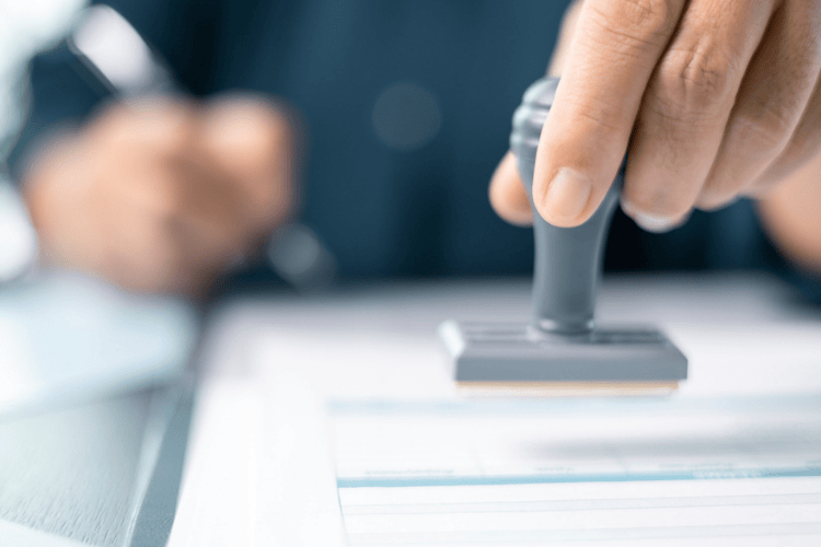 Oficial carimbando documentos para cidadania italiana.